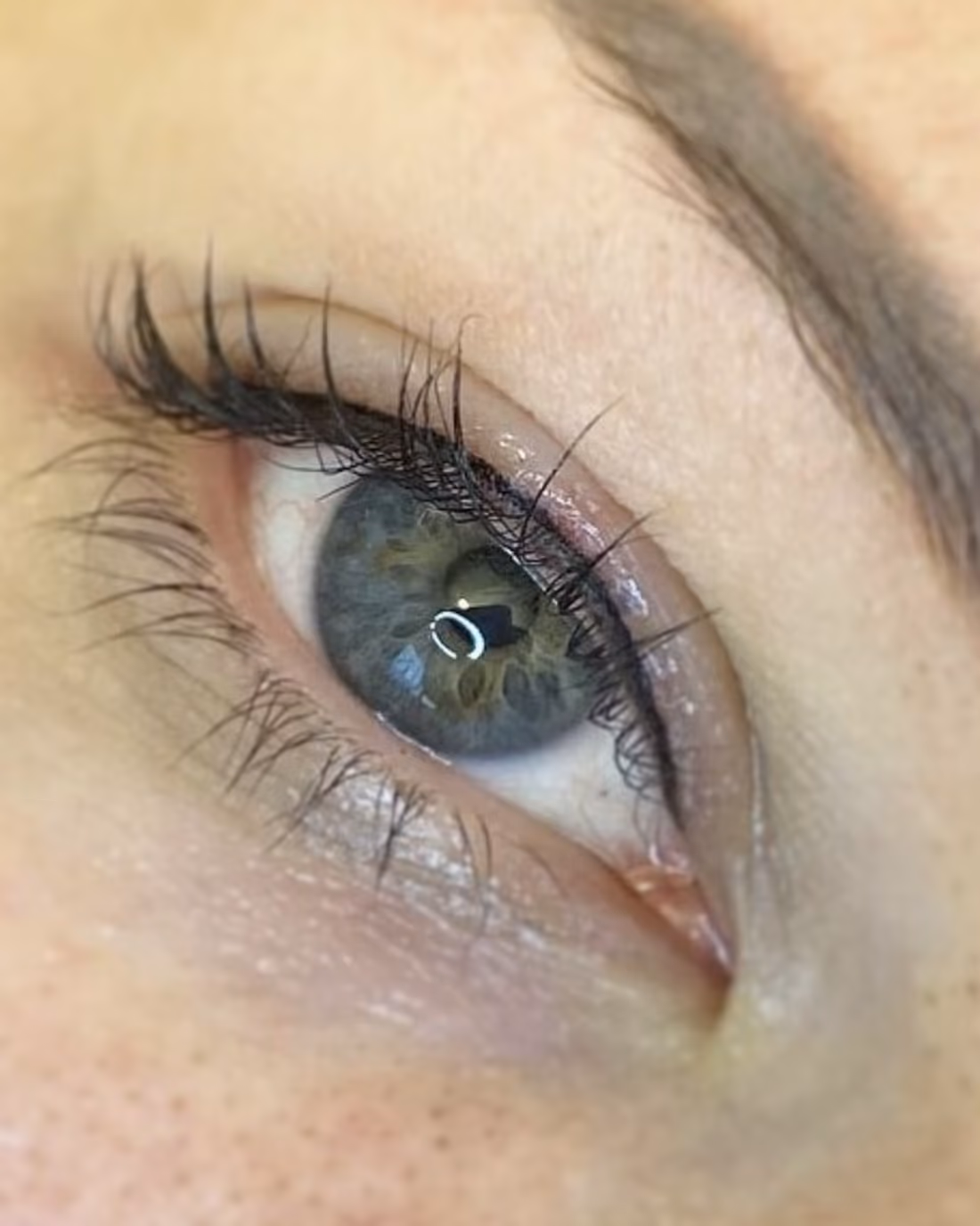 Ohut eyeliner-pigmentointi silmän ripsirajassa, luonnollinen ja tarkka linja